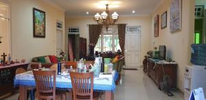 KalasanKumara Homestay Jogja的一间带桌椅和吊灯的用餐室