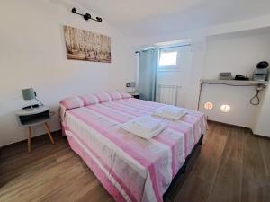 摩德纳Alloggiamo的一间卧室配有一张带粉色和白色条纹床单的床