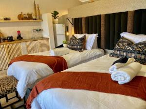 希尔克雷斯特Fever Tree Guesthouse的酒店客房,配有两张带毛巾的床