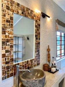 希尔克雷斯特Fever Tree Guesthouse的一间带石制水槽和镜子的浴室