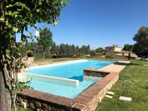 Osteria Delle NociLuxury Resort with swimming pool in the Tuscan countryside, Villas on the ground floor with private outdoor area with panoramic view的一个带有挡墙的庭院内的游泳池