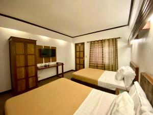 Lingayen艾尔普艾尔托玛丽纳海滩度假胜地及度假俱乐部的酒店客房设有两张床和电视。