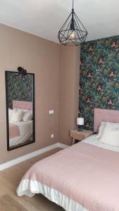曼萨纳雷斯DIVINA GUEST HOUSE的一间卧室设有一张大床和一个大镜子