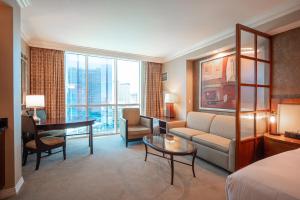 拉斯维加斯NO RESORT FEES-MGM StripView Adjoining Suites F1 View的酒店客房配有一张床、一张沙发和一张书桌。