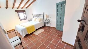 钦琼Casa Rural Casasola的卧室配有1张床,铺有瓷砖地板。