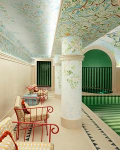 巴黎Le Grand Mazarin的一间拥有彩绘天花板、柱子和椅子的客房