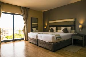 马普托WL Hotel Maputo City Center Mozambique Collection的一间卧室设有一张大床和一个大窗户