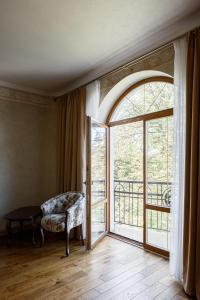 伊万诺-弗兰科夫斯克GANZ HOTEL的客厅设有大窗户和椅子