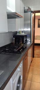 马德里Habitaciones individuales en apartamento turístico的厨房配有炉灶和洗衣机。