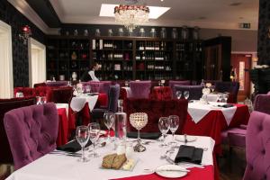 贝尔马利特塔尔波特酒店的一间设有白色桌子和紫色椅子的用餐室