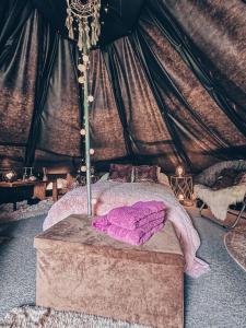 Glamping in - luxury tent的帐篷内一间卧室,配有一张床