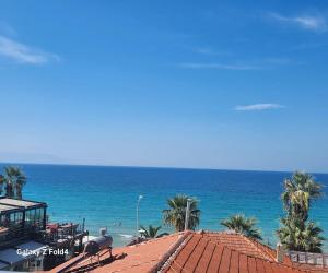 库萨达斯Lulubay Rooms & Suites的享有棕榈树海滩和大海的景色