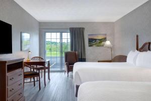 埃德门兹顿埃德蒙斯顿戴斯酒店的酒店客房设有两张床、一张桌子和一张桌子。