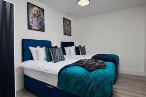 拉格比The Stunning Central Rugby Gem - Sleeps 10的一间卧室配有一张带蓝白色床单的大床