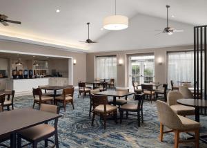 萨默塞特萨默塞特希尔顿酒店霍姆伍德套房酒店的用餐室设有桌椅和窗户。