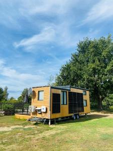 KittlitzTiny House im Spreewald的停在田野中的黄色小房子