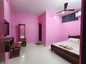 蓬蒂切里Le Paradise Inn的卧室设有粉红色的墙壁、一张床和水槽
