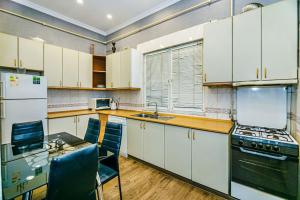 巴库Baku Apartment CH的厨房配有白色橱柜和桌椅