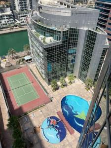 迪拜"Luxurious 2 Bed, 3 Bath Apartment in Dubai Marina - Steps Away from JBR!"的网球场和网球拍的顶部景色