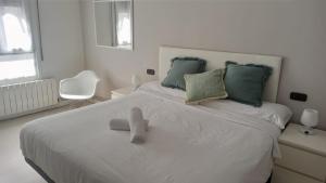 贝梅奥Ohana, Apartamento-CENTRICO-WIFI-ASCENSOR- PARKING PRIVADO GRATIS-SIN CUESTAS的一张白色的床,上面有泰迪熊