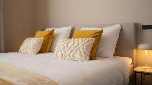 法尔肯堡Hotel Kint的一张白色的床,上面有黄色枕头