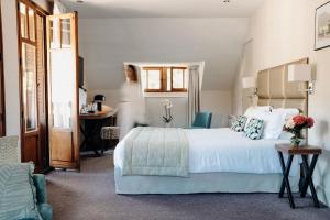 塔卢瓦尔Hotel Le Cottage Bise的卧室配有一张白色大床和一张书桌
