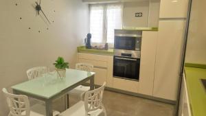 贝梅奥Ohana, Apartamento-CENTRICO-WIFI-ASCENSOR- PARKING PRIVADO GRATIS-SIN CUESTAS的厨房配有桌椅和冰箱。