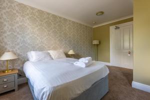 贝德福德林场庄园酒店的一间卧室配有一张带白色床单的大床