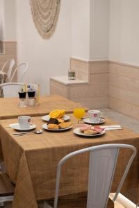 塞维利亚U-Sense For You Hostel Sevilla的一张桌子,上面放着两盘食物和一杯橙汁