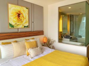 清迈The Astra cozy living suite的卧室的墙上装饰有黄色的花画