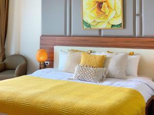 清迈The Astra cozy living suite的一间卧室配有一张黄色毯子床