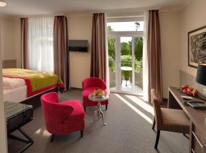 奥斯赛拜-屈隆斯博恩库伦斯伯恩最大海滩酒店的酒店客房带一张床、一张桌子和椅子