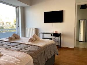雅典Spacious and Sunkissed 3BR & 2 Bathrooms Apartment的一间卧室配有两张床和一台平面电视