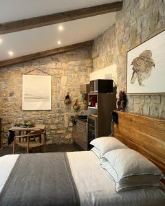 BouillarguesBoisBolchet Ecolodge-SPA的一间卧室设有一张床和石墙