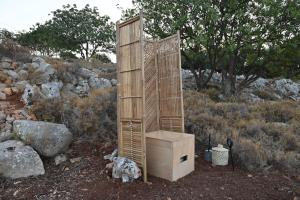 YeránionStar Sleep Gerani Rethymno的木质结构,在田野上设有厕所