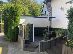 科布伦茨Moselidylle und Cityflair - Ferienwohnung Beth的庭院设有楼梯、雨伞和植物
