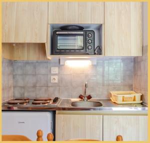 莫尔济讷Appartement T2 Téléphérique de NYON Morzine的厨房配有水槽和微波炉