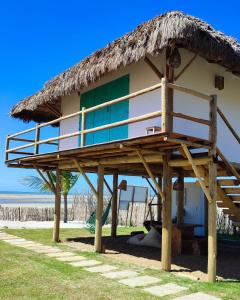 伊塔雷马Villa Água Viva的海滩上带茅草屋顶的房子