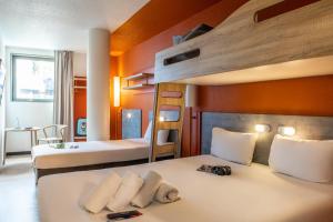 庞坦巴黎庞坦门宜必思快捷酒店的一间卧室配有两张床和一张双层床。