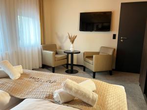 新基兴Hotel Da Toni的酒店客房带一张床、椅子和电视