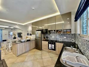 迪亚尼海滩阿曼尼豪华公寓的一间带冰箱和水槽的大厨房