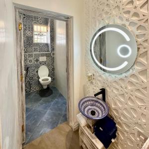 迪亚尼海滩阿曼尼豪华公寓的浴室设有卫生间和墙上的镜子。