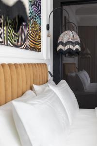 卢布尔雅那AS Boutique Hotel, superior的一间卧室配有床、绘画和灯