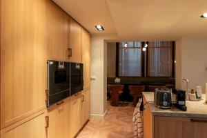 阿姆斯特丹Newly renovated luxurious 200 SQM loft in city centre的一间带木制橱柜的厨房和一间用餐室