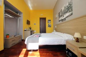 罗马LHG Comfy Rooms的卧室设有一张白色大床和黄色墙壁