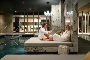 巴拉顿菲赖德Hotel Vinifera Wine & Spa 5 Stars Superior的坐在游泳池床边的男女