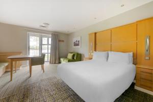 康福斯松湖钻石度假酒店的卧室配有一张白色大床和一张书桌