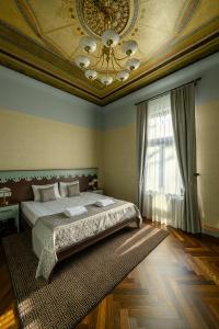 利耶帕亚Roze Peldu Residence的一间卧室配有一张床,天花板配有吊灯
