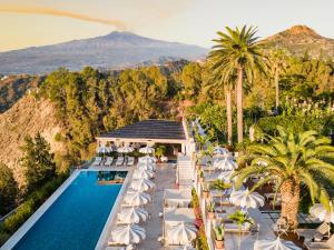 陶尔米纳圣多米尼克宫酒店的享有带游泳池和山脉的度假村的空中景致