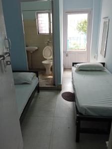 加尔各答Centerpoint Guest House的客房设有两张床和一间带水槽的浴室